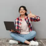 Girl with a laptop and thumbs up
